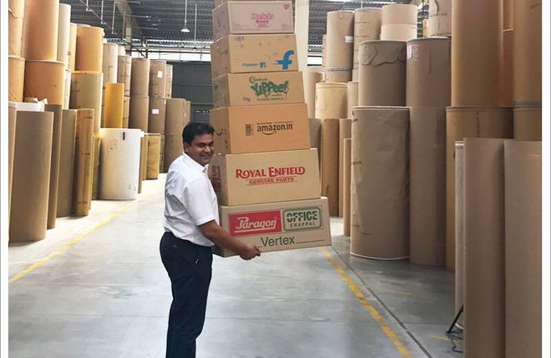 Worker carrying corrugated boxes in the paper roll warehouse