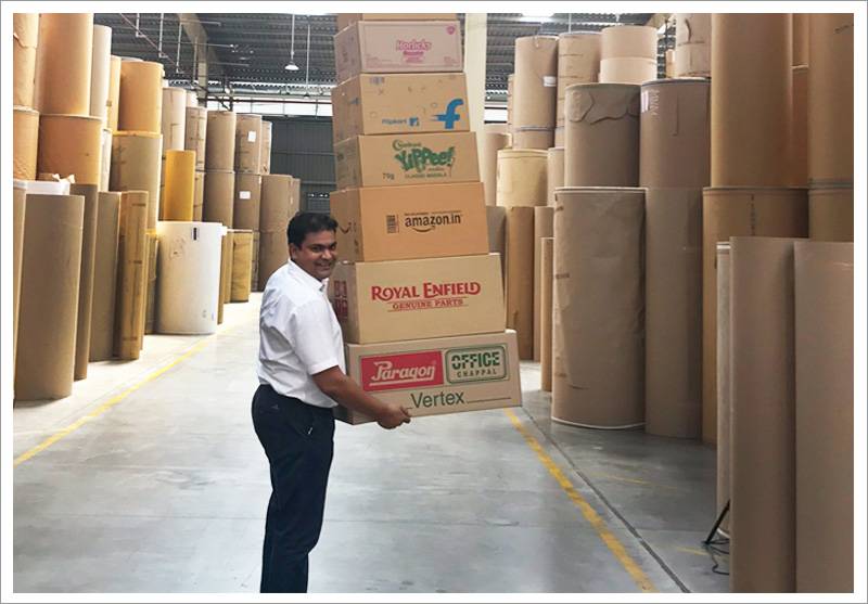 Worker carrying corrugated boxes in the paper roll warehouse